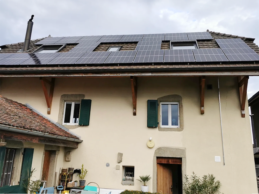 Installation de panneaux solaires sur le toit d'un immeuble dans le canton de Fribourg